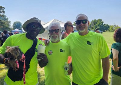 three smiling volunteers and a dog